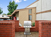 Thumbnail 16 of 41 - a silver grill in front of a brick fence and a house