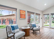 Thumbnail 30 of 41 - a living room with two chairs and a table and sliding glass doors
