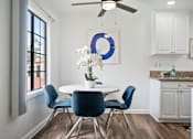 Thumbnail 10 of 28 - a dining area with a round table and blue chairs