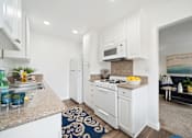 Thumbnail 12 of 28 - a kitchen with white cabinetry and granite countertops