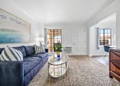 Thumbnail 2 of 28 - a living room with a blue couch and a glass coffee table