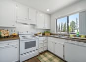 Thumbnail 10 of 29 - a white kitchen with white appliances and white cabinets