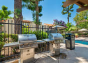 Thumbnail 28 of 40 - two bbq grills next to a swimming pool with trees