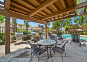 Thumbnail 27 of 40 - a patio with a table and chairs next to a swimming pool