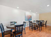 Thumbnail 32 of 40 - a dining room with tables and chairs and a painting on the wall