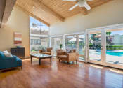 Thumbnail 30 of 40 - a living room with a view of a pool and sliding glass doors