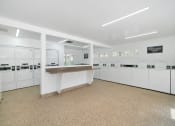 Thumbnail 39 of 40 - a laundry room with a counter and white cabinets