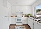 Thumbnail 8 of 36 - a white kitchen with white appliances and white cabinets