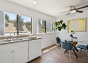 Thumbnail 6 of 36 - a kitchen with white cabinets and a dining room with a table and chairs