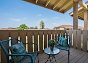 Thumbnail 21 of 36 - a patio with two chairs and a table on a deck