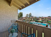 Thumbnail 22 of 36 - a balcony with two chairs and a view of a swimming pool