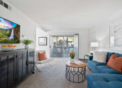 Thumbnail 22 of 38 - a living room with a blue couch and a sliding glass door