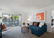 Thumbnail 21 of 38 - a living room with a blue couch and a coffee table and a sliding glass door