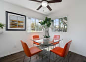 Thumbnail 23 of 38 - a dining room with a glass table and chairs and a ceiling fan