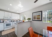 Thumbnail 24 of 38 - a kitchen and dining room with white appliances and white cabinets