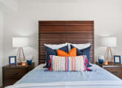 Thumbnail 34 of 38 - a bedroom with a bed with pillows and a wooden headboard