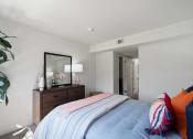 Thumbnail 32 of 38 - a bedroom with a bed and a dresser with a mirror