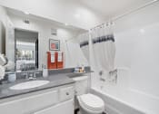 Thumbnail 31 of 38 - a bathroom with a sink toilet and tub and a mirror