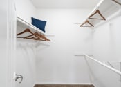 Thumbnail 35 of 38 - a walk in closet with white walls and a white shower and a blue pillow