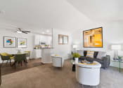 Thumbnail 5 of 38 - a living room with a couch and a coffee table and a kitchen in the background