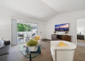 Thumbnail 4 of 38 - a living room with a couch and a glass coffee table and a tv