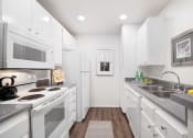Thumbnail 8 of 38 - a white kitchen with stainless steel appliances and white cabinets