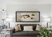 Thumbnail 31 of 49 - a living room with a couch and a painting on the wall