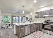 Thumbnail 1 of 24 - A modern kitchen with a large island and stainless steel appliances.