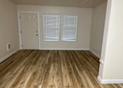 Thumbnail 10 of 16 - A room with wooden flooring and a white door.