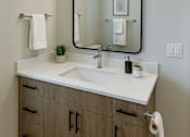 Thumbnail 11 of 24 - A bathroom with a sink, mirror, and towel rack.