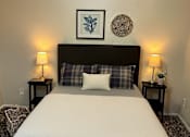 Thumbnail 8 of 17 - A bed with a white comforter and a plaid pillowcase is in the image.