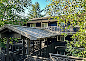 Thumbnail 23 of 27 - A house with a metal roof and a balcony.