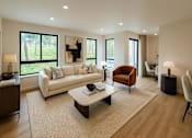 Thumbnail 16 of 24 - A living room with a white couch and a brown armchair.