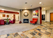 Thumbnail 17 of 21 - A living room with a fireplace and a clock on the wall.