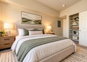 Thumbnail 5 of 21 - A bedroom with a large bed and a painting on the wall.