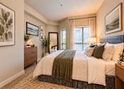 Thumbnail 6 of 21 - A bedroom with a large bed and a painting on the wall.