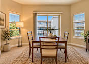 Thumbnail 2 of 21 - A dining room with a table set for four.