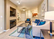 Thumbnail 8 of 21 - A living room with a fireplace and a couch.