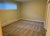 Thumbnail 14 of 15 - A room with a carpeted floor and a door on the right side.