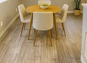 Thumbnail 5 of 15 - A dining room with a wooden table and chairs.
