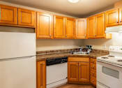 Thumbnail 3 of 8 - A kitchen with wooden cabinets and white appliances.
