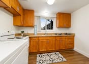 Thumbnail 8 of 11 - A kitchen with wooden cabinets and a white stove.