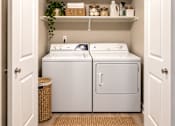 Thumbnail 8 of 13 - A white washing machine and dryer in a small laundry room.