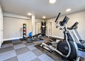 Thumbnail 9 of 13 - A gym with a treadmill, weights, and a squat rack.