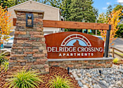 Thumbnail 13 of 13 - A sign for Delridge Crossing Apartments is displayed in front of a stone pillar.