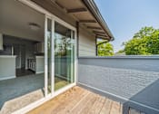 Thumbnail 5 of 20 - A patio with a glass door leading to a kitchen.