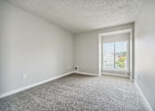 Thumbnail 14 of 20 - A room with a window and carpeted floor.
