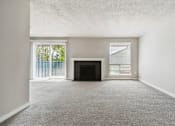 Thumbnail 7 of 20 - A living room with a fireplace and sliding glass doors.