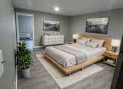 Thumbnail 5 of 21 - A modern bedroom with a large bed and a potted plant.