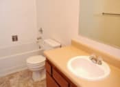 Thumbnail 10 of 13 - A bathroom with a toilet, sink, and mirror.